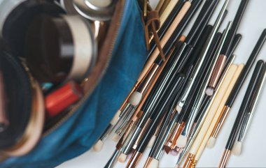 Makyaj fırçaları ve çantasında profesyonel kozmetik ürünler var.