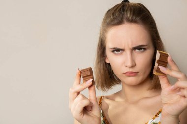 Çikolata parçalarını tutan genç esmer kadın. Metin için boşluk