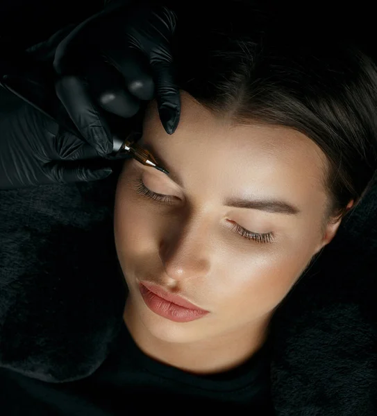 年轻的黑发女士有眉毛永久化妆程序在美容室 顶部视图 — 图库照片