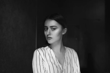 Üzgün, genç, esmer bir kadının tek renkli iç portresi şık kıyafetler giyer. Metin için boşluk