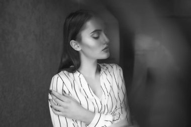 Üzgün, çekici, esmer bir kadının tek renkli portresi şık kıyafetler giyer. Metin için boşluk