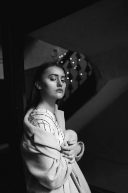 Hüzünlü, sevimli, esmer bir kadının tek renkli portresi şık kıyafetler giyer.