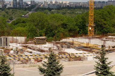 Ekipman ve yapı malzemelerinin bulunduğu inşaat alanı çok katlı bir binanın inşaatına hazır.