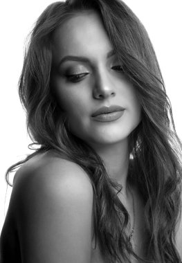 Kıvırcık saçlı ve doğal makyajlı güzel bir kadının stüdyo portresi. Siyah ve beyaz çekim