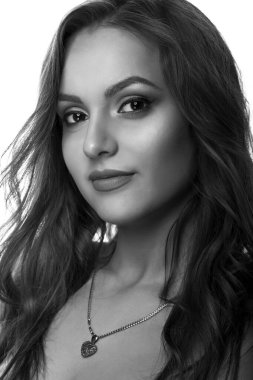 Kıvırcık saçlı ve doğal makyajlı genç bir kadının stüdyo portresi. Siyah ve beyaz çekim