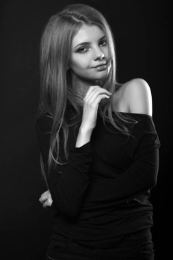 Çıplak omuzlarıyla poz veren hoş bir genç kadının tek renkli portresi.