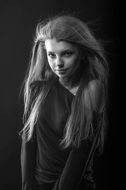 Çıplak omuzlarıyla poz veren baştan çıkarıcı genç bir kadının tek renkli portresi.