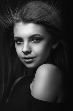 Çıplak omuzlarıyla poz veren harika bir genç kadının tek renkli portresi.