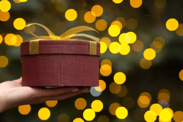 Woman Hand Holding Gift Box Bow Closeup Background Christmas Tree — Stock Photo, Image