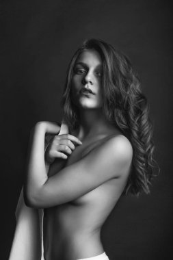 Güzel genç manken beyaz erkek gömleği giyer ve stüdyoda çıplak pozlar verir. Tek renkli çekim.