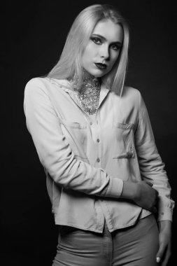 Parlak makyajlı ve folyoyla stüdyoda poz veren muhteşem sarışın bir model. Tek renkli çekim.