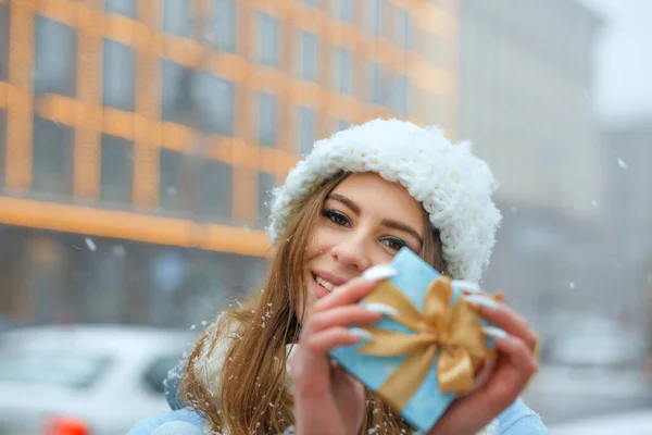 Cute Blond Woman Wears White Knitted Cap Holding Blue Gift — Stock Photo, Image