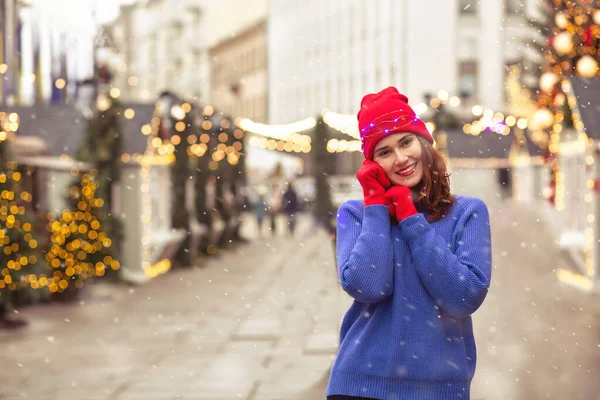 在市中心城市广场的圣诞集市上 快乐的黑发女人头戴红帽子 身穿蓝色毛衣 案文的篇幅 — 图库照片