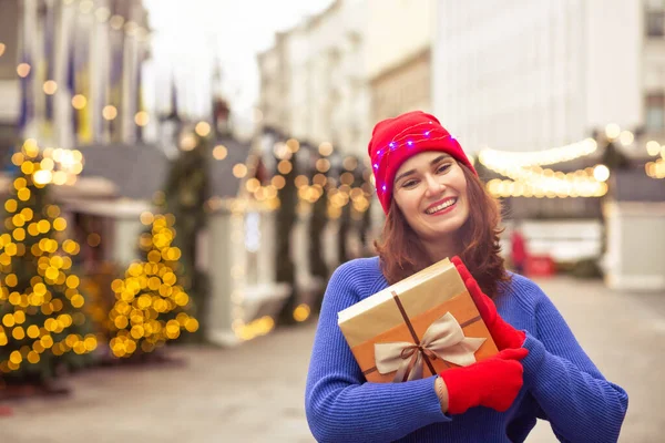 Cheeful Brunette Lady Wears Red Hat Blue Sweater Holding Gift — Stock Photo, Image