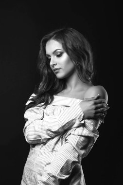 Doğal makyajlı, stüdyoda dramatik ışıkla poz veren sevimli üzgün kadın. Siyah beyaz portre