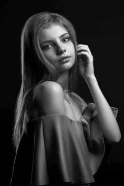 Stüdyo monokrom portresi. Çıplak omuzlarıyla poz veren lüks bir genç kadın.