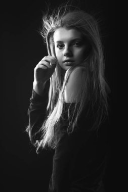 Çıplak omuzlarıyla poz veren çekici genç bir kadının tek renkli portresi.