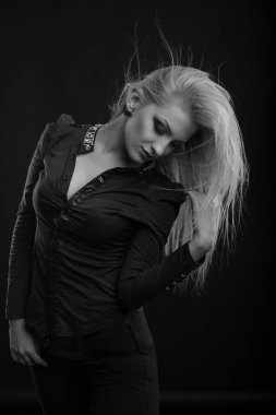 Mükemmel makyajlı ve rüzgarda saçı olan çekici sarışın kadın bluz giyer, stüdyoda poz verir. Siyah ve beyaz çekim