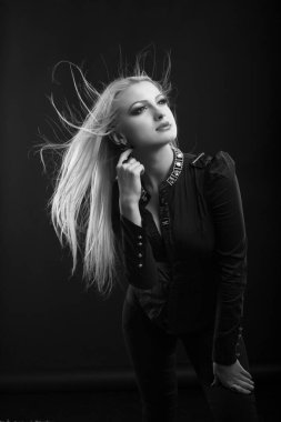 Mükemmel makyajlı ve rüzgarda saçı olan romantik sarışın kadın stüdyoda poz veren bir bluz giyiyor. Siyah ve beyaz çekim