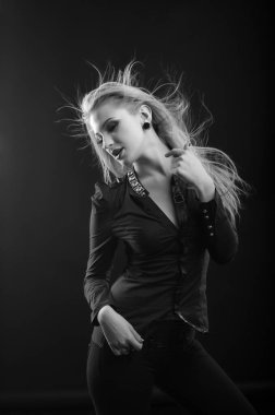 Mükemmel makyajlı, uzun dalgalı saçlı tutkulu sarışın kadın bluz giyer, stüdyoda poz verir. Siyah ve beyaz çekim