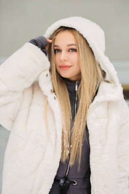 Kar parkında poz veren güzel bir genç kadın.