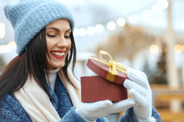 Pleased Brunette Woman Winter Coat Holding Gift Box Christmas Fair — Stock Photo, Image
