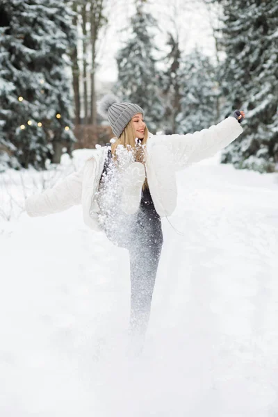 森の中で雪と遊ぶ素晴らしいブロンドの女性 — ストック写真