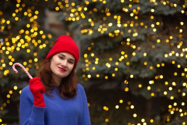 Noel ağacında elinde şeker olan güzel esmer kadın. Metin için boşluk
