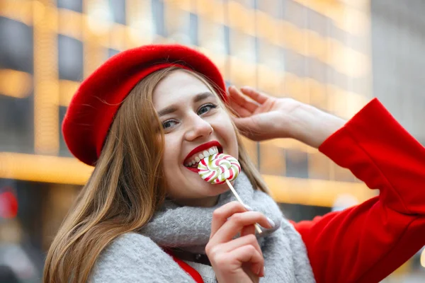 Pretty Young Woman Red Coat Biting Sweet Candy Empty Space — Stock Photo, Image