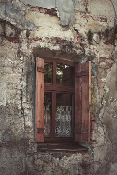 Старое окно на разбитой стене — стоковое фото