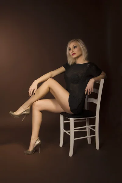 Vacker kvinna sitter på stol — Stockfoto