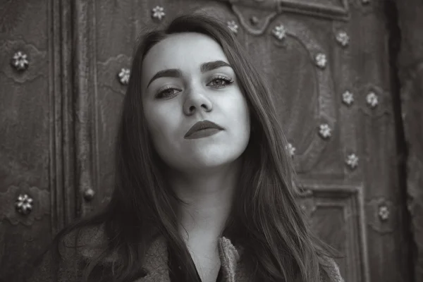 Pretty woman near an old door — Stock Photo, Image