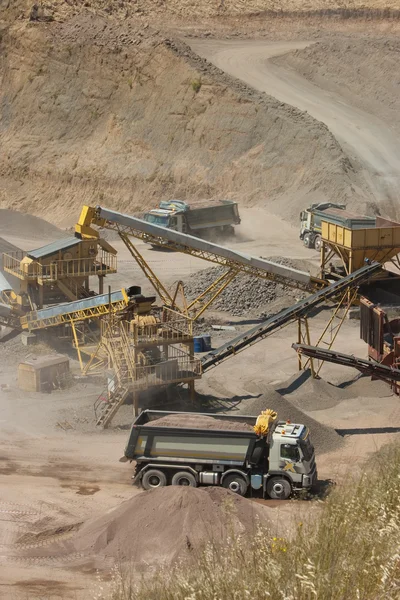 Vrachtwagen en bulldozer werken in de steengroeve — Stockfoto