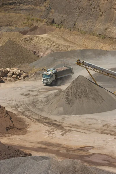 Vrachtwagen en bulldozer werken in de steengroeve — Stockfoto