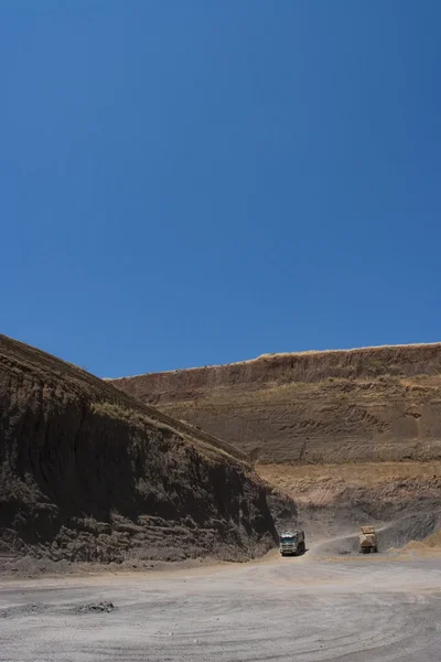 Vrachtwagen en bulldozer werken in de steengroeve — Stockfoto