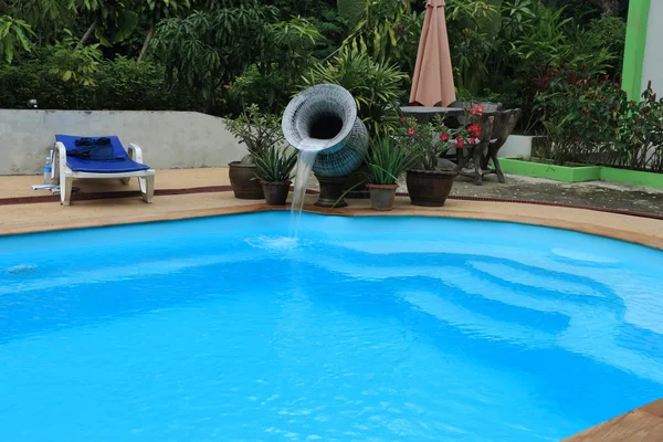 Каскад воды из урны в бассейне — стоковое фото