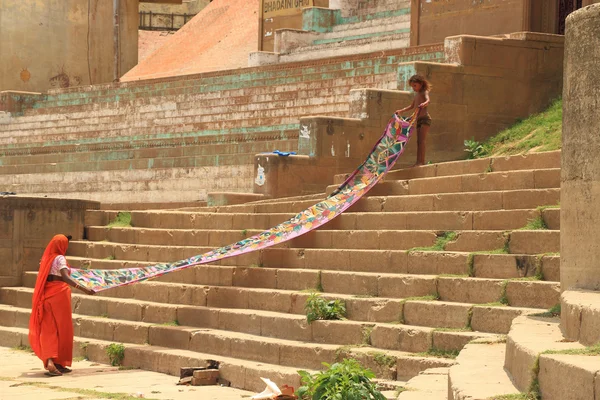 India woman and girl spreading out a sheet for drying — Stock Photo, Image