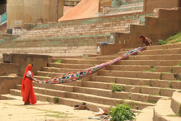 India woman and girl spreading out a sheet for drying — Stock Photo, Image