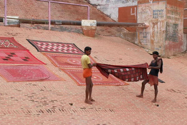 Two india men spreading out a colorful sheet — Stock Photo, Image