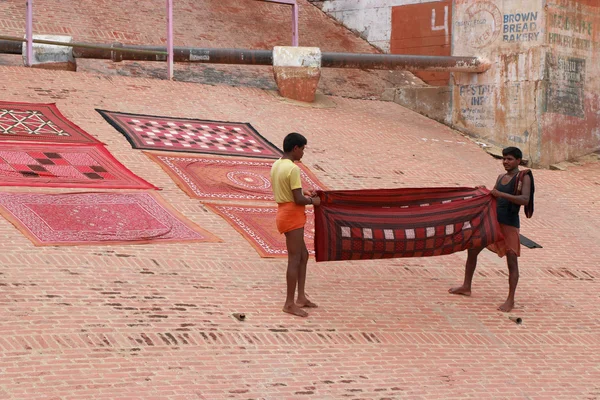 Two india men spreading out a colorful sheet — Stock Photo, Image