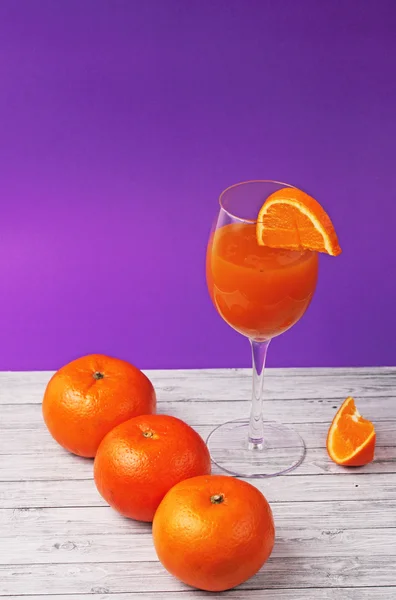 Vidro de suco de laranja com laranjas — Fotografia de Stock