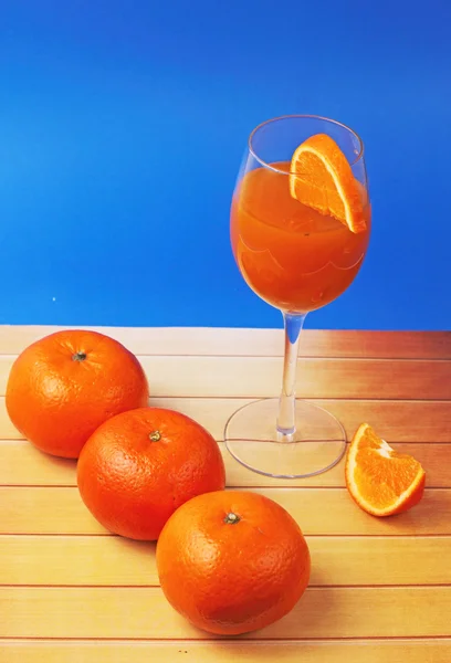 Vidro de suco de laranja com laranjas — Fotografia de Stock