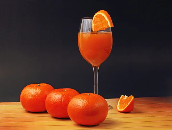 Vidro de suco de laranja com laranjas — Fotografia de Stock