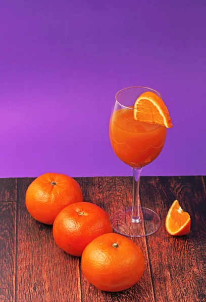 Vidro de suco de laranja com laranjas — Fotografia de Stock