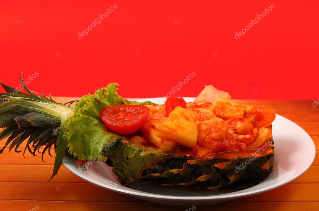 sweet and sour shrimp served in a pineapple thai style with a