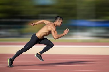 Sprinter leaving  on the running track.  clipart