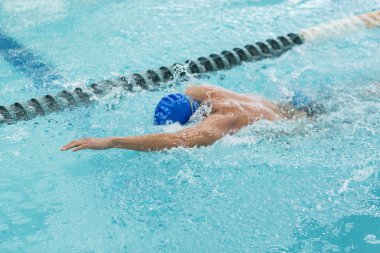 Kelebek yüzme tekniği olan genç bir atletik..