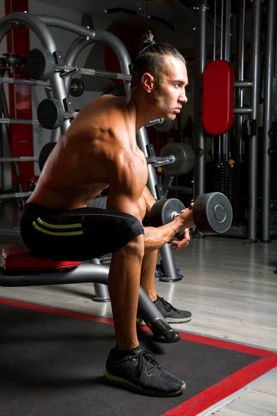 Joven musculoso en gimnasio — Foto de Stock