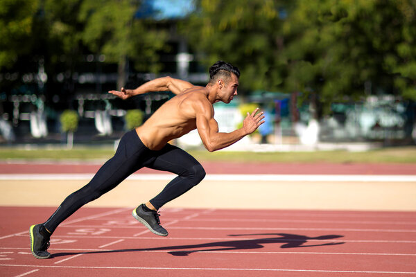 Young muscular man ready to start a track meet.