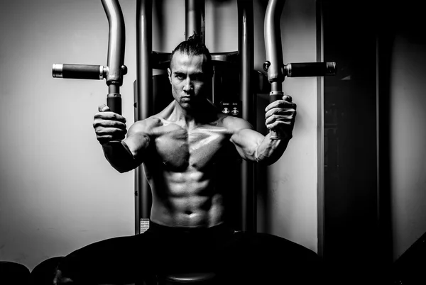 Joven musculoso en gimnasio — Foto de Stock